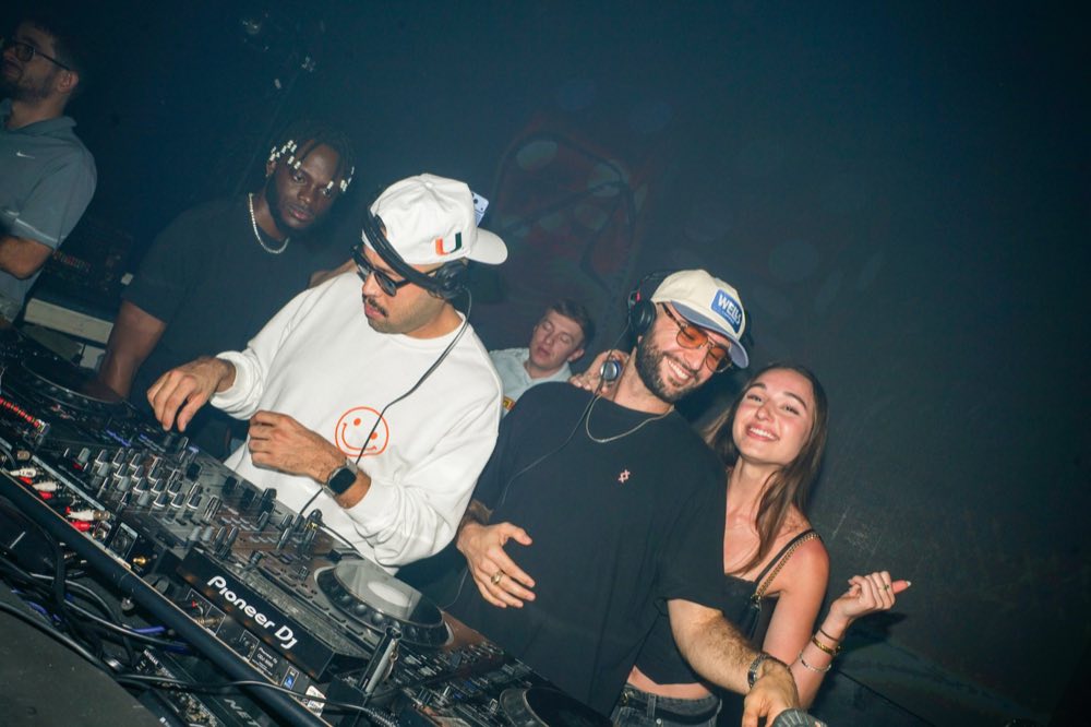 The Highly Recommended duo behind the decks mid-set, crowd around them